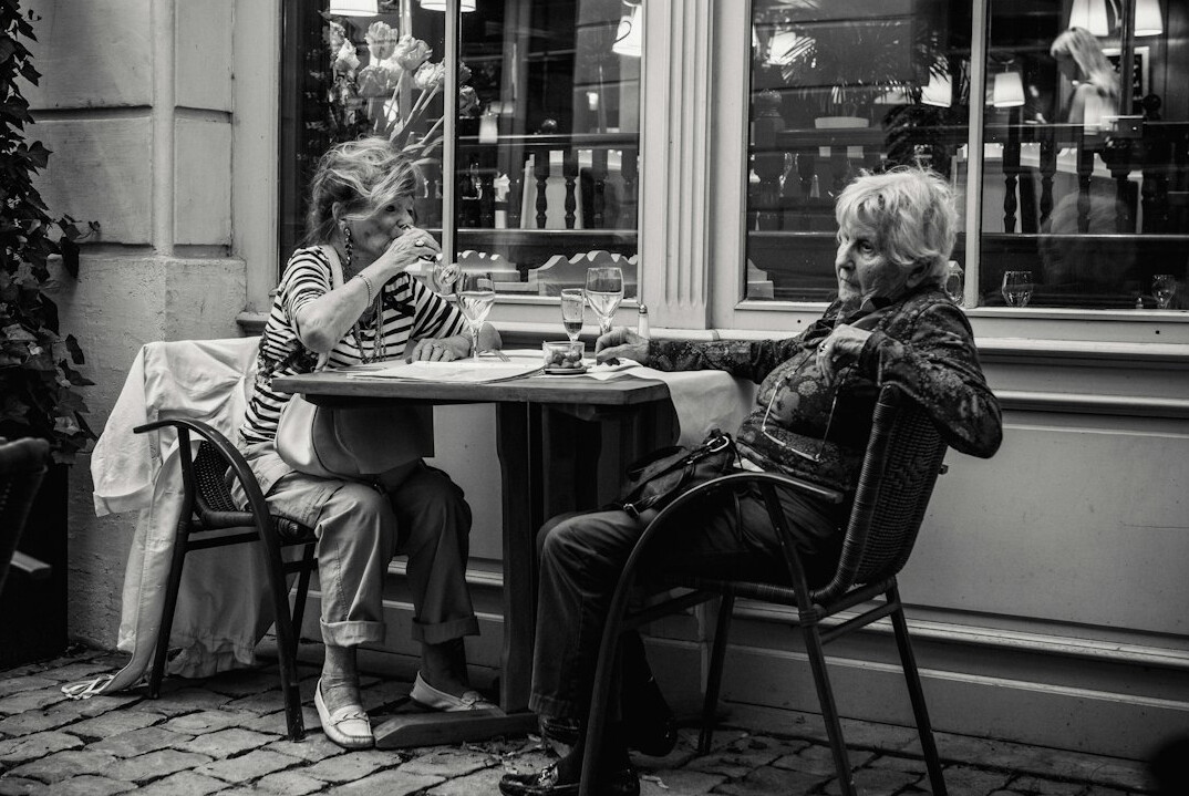 Group of smiling seniors enjoying coffee together in a community room